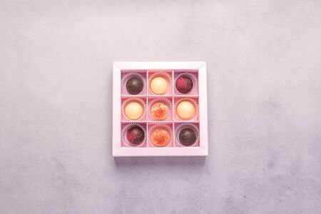 Chocolate candies in a festive box on a gray background. Holiday concept. Minimalism food dessert....
