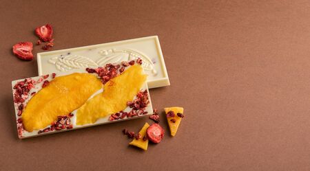 Chocolate white fruit whole tile decorated with slices of fruit nuts and slices on a brown...