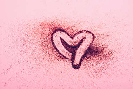 Red heart symbol of love from sparkles pink background. Valentines day cosmetics concept. Horizontal frame copy space.の写真素材