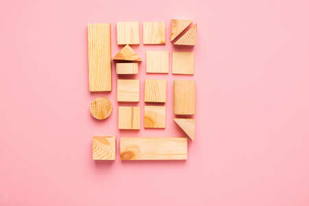 Wooden cubes lie in a row on pink background. The concept of using environmentally friendly natural...