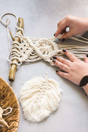 Female hands weave macrame the home workshop. Boho lifestyle. Hobby hobby concept. Selective focusの写真素材