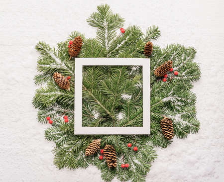 Christmas background template for advertising cards. Fluffy green spruce branches white frame on a...
