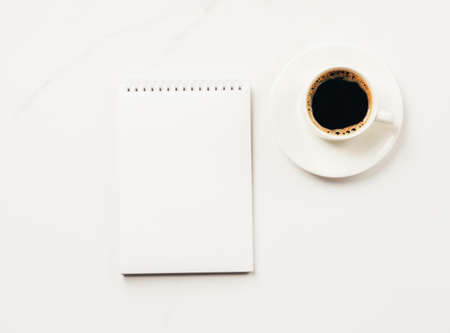 Notepad blank for to-do list or goals cup of coffee on a light background. Flat lay top view. Planning conceptの写真素材