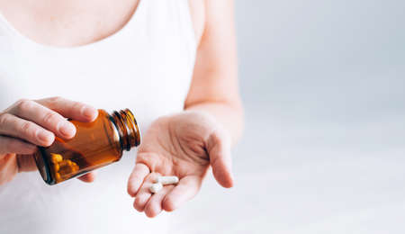 Medical pills tablets in a bottle on a female hand. Health and medicine. Selective focus. Copy spaceの写真素材
