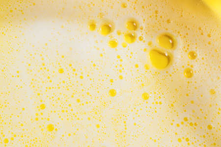 Background lush airy foam detergent bath gel bathing bright yellow. Fashion beauty concept top view...