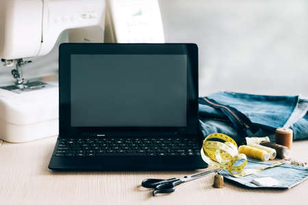 Concept for online learning and watching a sewing lesson on a laptop. Template for advertising sewing clothing repair coursesの写真素材