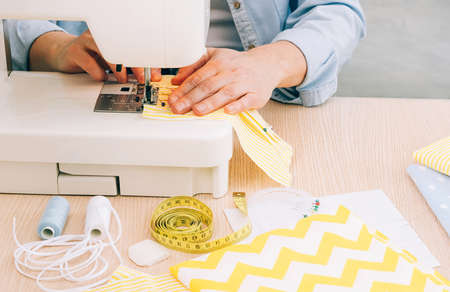 Womens hands sew homemade medical face mask sewing machine during coronavirus pandemic. Homemade medical mask processの写真素材