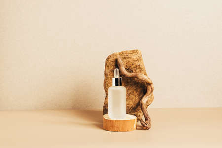 Bottle of cosmetic product gel collagen serum oil on pastel beige background modern abstract podiumの写真素材