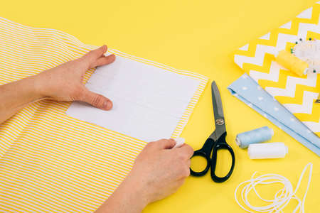 Womens hands sew homemade medical face mask sewing machine during the coronavirus pandemic. DIY...