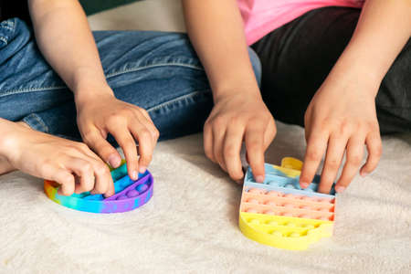 Childrens hands play fashionable sensory bright toy anti-stress pop it. Silicone toy with soft...
