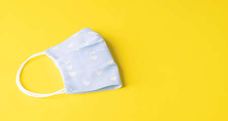Eco-friendly reusable cloth protective mask yellow background. Homemade breathing mask, protection...