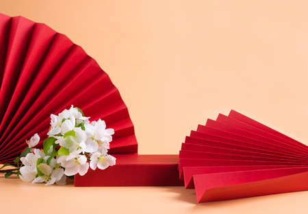 Abstract fashion podium for advertising cosmetics products. Red podium paper oriental fan pink pastel backgroundの写真素材