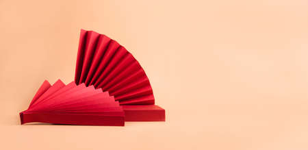 Abstract fashion podium for advertising cosmetics products. Red podium paper oriental fan pink pastel backgroundの写真素材