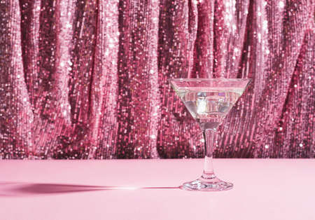 Martini cocktail background pink shiny curtain. Alcoholic classic drink with ice in elegant glass for the celebrationの写真素材