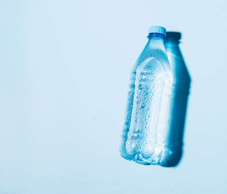Pure drinking mineral water in a transparent plastic bottle on a blue background.の写真素材