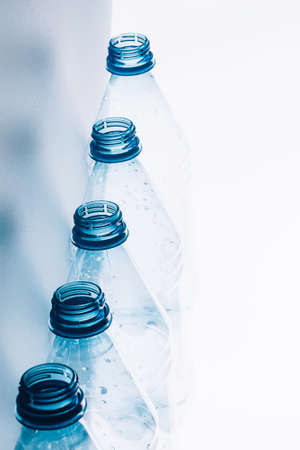 Used transparent plastic bottles on light blue background. Group of plastic for reuse recycling. Waste bottle recyclingの写真素材