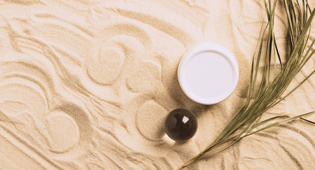 Set of cosmetic products jar bottle bottle beach sand background. Abstract podium natural materials product presentation sandy backgroundの写真素材