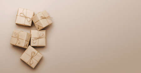 Gifts in eco-friendly paper packaging on a trendy beige background. Layout mockup copy space concept minimalismの写真素材