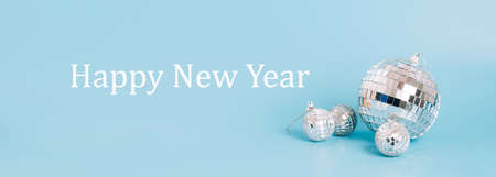 Disco ball on a pastel blue background, text Happy new year . Festive mockup minimalism party conceptの写真素材