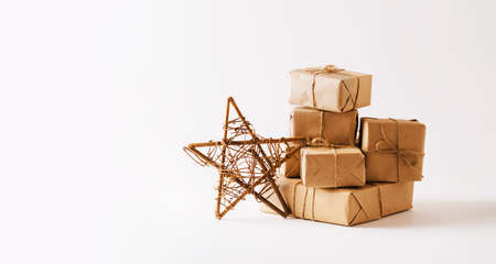 Handmade star, gifts in simple paper packaging light background. Festive composition for Christmas or New Yearの写真素材