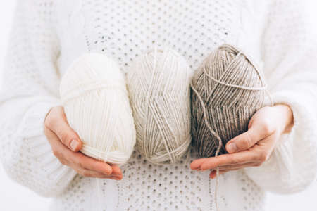 Womens hands hold threads for knitting, made of natural environmentally friendly wool, close-up. Hobby home needleworkの写真素材