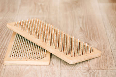 Sadhu board with nails on light wooden background, copy space. The practice of standing on nails