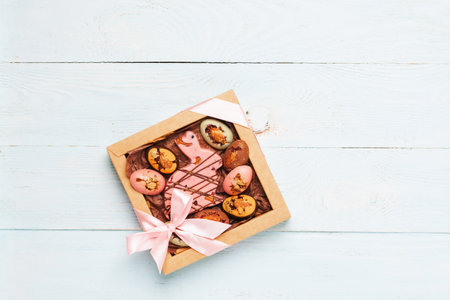 Easter composition box of chocolate eggs easter bunny wooden pastel background. Happy Easter concept