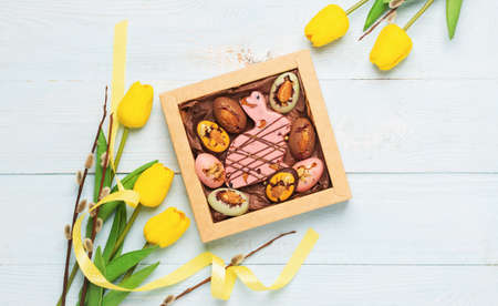 Easter composition spring flowers yellow tulips box of chocolate eggs easter bunny pastel backgroundの写真素材