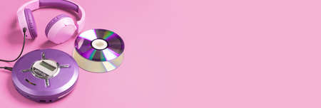 Personal compact portable CD player disks purple headphones on a pink background.の写真素材