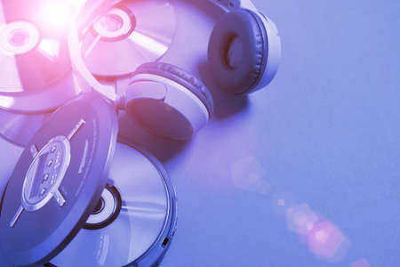 Personal compact portable CD player disks headphones blue neon background, Top viewの写真素材