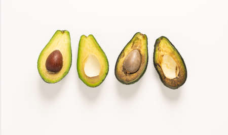 Ripe and spoiled rotten fruit vegetables avocado in a cut, white background, copy spaceの写真素材