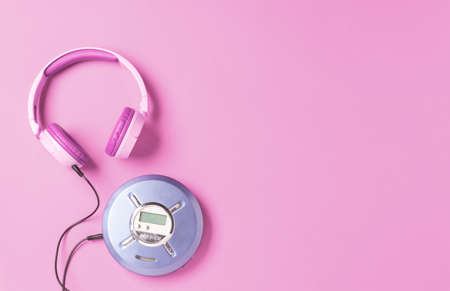 Personal compact portable CD player disks purple headphones on a pink background.の写真素材