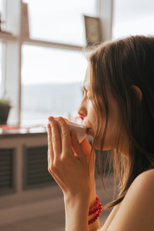 Woman sit on the floor and drink tea from herbs and flowers. Tea ceremony during relaxation harmonyの写真素材