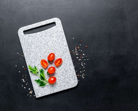 Marble white cutting board ripe spice cherry tomatoes black background. Ingredients fresh vegetablesの写真素材