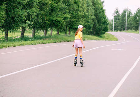 Preteen girl roller skating in the park, doing outdoor activities. Horizontal frame