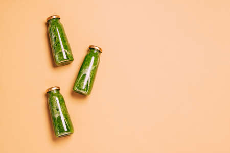 Green vegetable fruit cocktail, bottled drink smoothie, beige background. Top copy spaceの写真素材