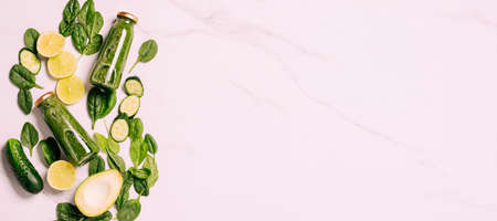 Green vegetable fruit smoothie, drink in bottles, pieces cucumber avocado apple spinach leavesの写真素材