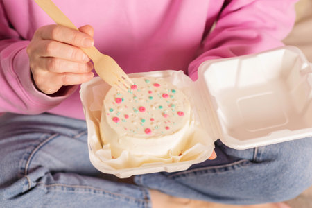 Woman is holding bento cake in her hands. Korean style cakes in box for one person