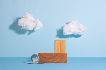 Podiums made of wooden figures and glass, blue background with white clouds, minimalist styleの写真素材