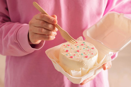 Woman is holding bento cake in her hands. Korean style cakes in box for one personの写真素材