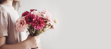 Girl holding a bouquet of pink flowers, selective focus. Festive composition for Mothers Day, copy spaceの素材