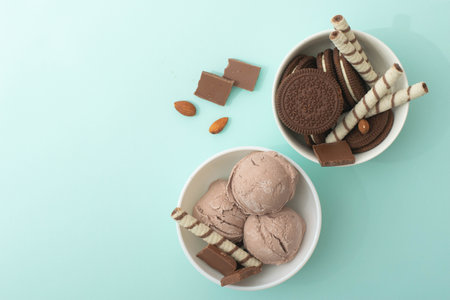 Chocolate homemade ice cream decorated with nuts, chocolate chips, wafer rolls, in white bowl. Summer cooling dessertsの写真素材