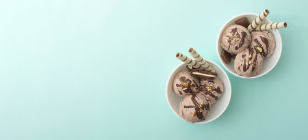 Chocolate homemade ice cream decorated with nuts, chocolate chips, wafer rolls, in white bowl. Summer cooling dessertsの写真素材