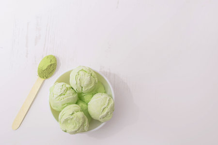 Homemade Green Matcha flavored Ice Cream in white bowls on a white kitchen table, copy space, flat lay, top viewの写真素材