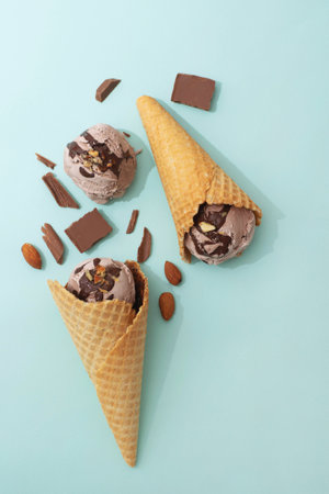 Chocolate ice cream in a waffle cone, blue background, flat lay, top view, copy space. Summer cooling dessertsの写真素材