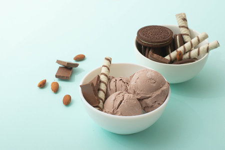 Chocolate homemade ice cream decorated with nuts, chocolate chips, wafer rolls, in white bowl. Summer cooling dessertsの写真素材