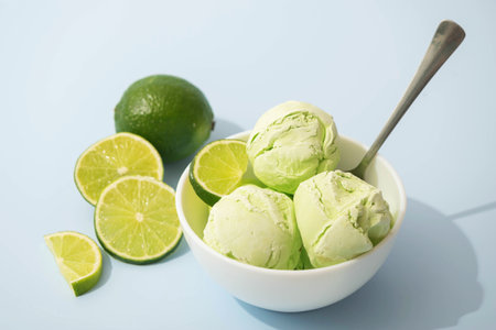 Ice cream with lime flavor and slices of fresh lime in a white bowl, white background, copy space. Summer cooling desserts,の写真素材