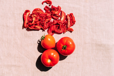 Fresh and dried tomatoes lie on the kitchen table, top view. Harvesting and processing of vegetables, vegetarianismの写真素材