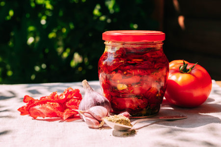 Dried tomatoes in a jar with spices and herbs. Autumn preparations, fermented vegetables. Home seasonal canningの写真素材