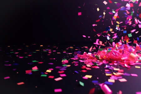 Festive Abstract background with scattered pink confetti, splashes, ribbons. Modern dark empty backgroundの素材